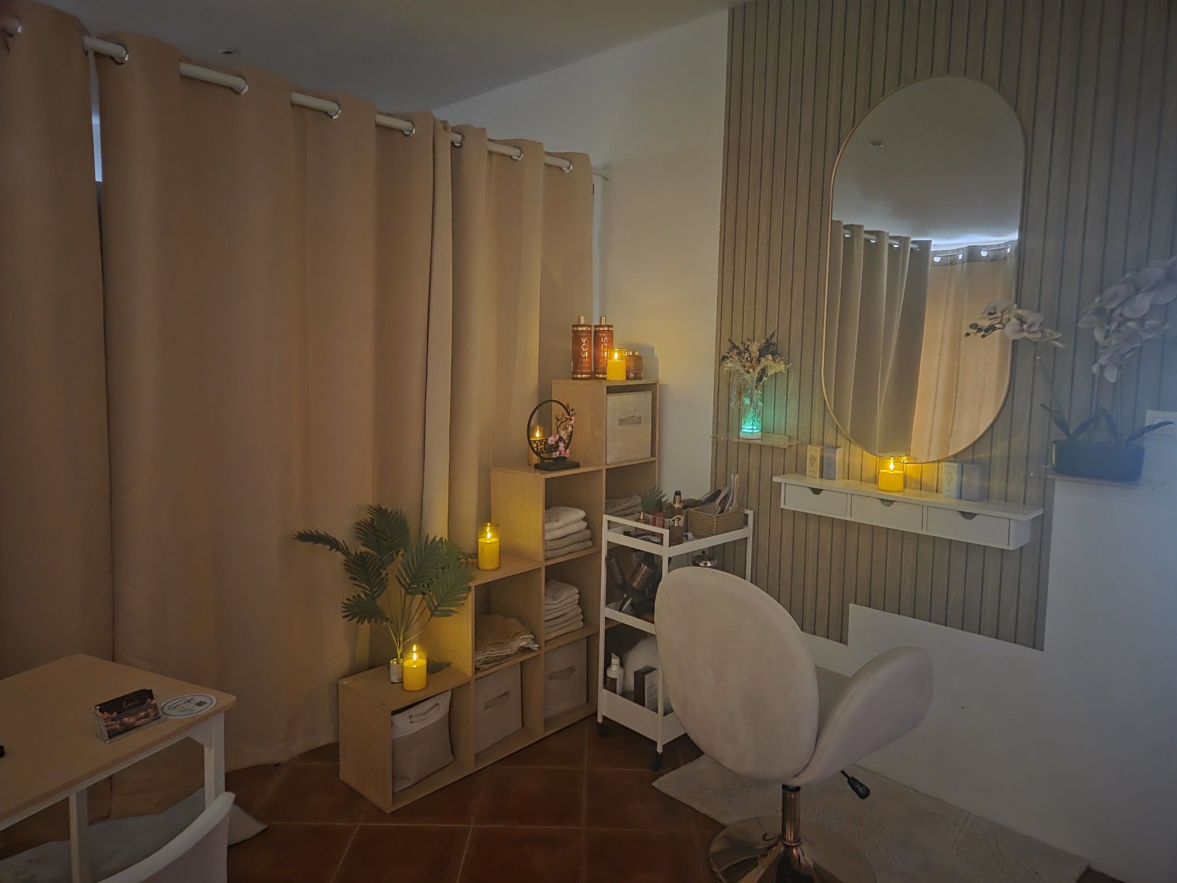 Le coin coiffage du salon, miroir ovale, bougies et fauteuil